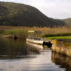 view of lake with boat surrounded by greenery