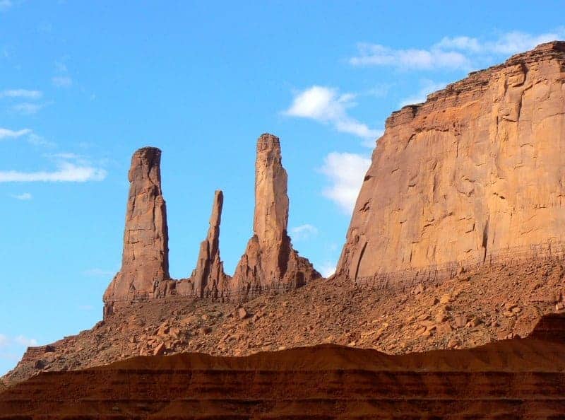 The three sisters (sandstone formations) stand tall in Monument Valley.
