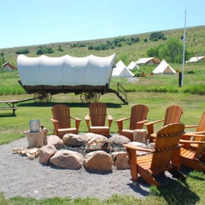 outdoor fire pit with tents in the background