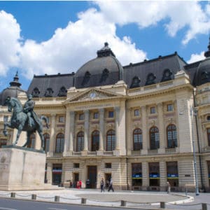 a large building with horse statue in front