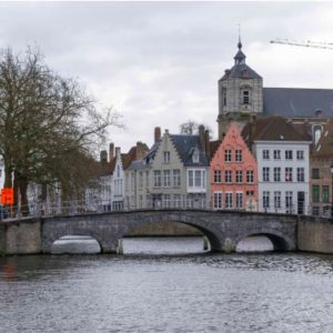 a bridge over a canal with buildings in the background