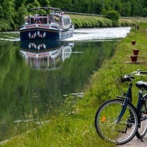 canal with cruise with bicycle in foreground