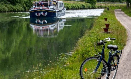 canal with cruise with bicycle in foreground