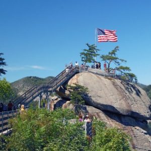 stairs leading up to large rock with american flag