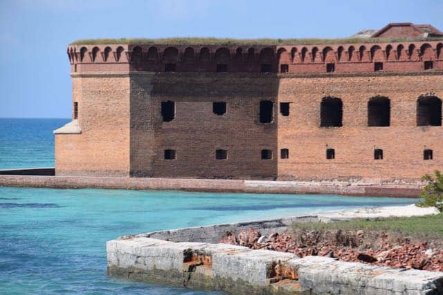A red brick historic fort surrounded by aqua colored water at off-the-beaten-path Dry Tortugas National Park.