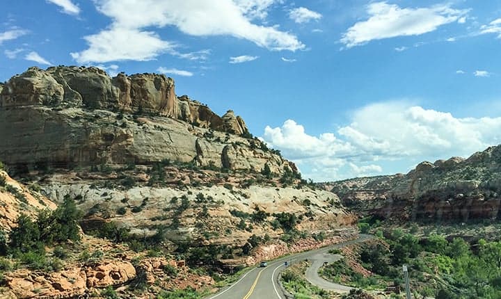 two-lane highway traveling through a rock canyon