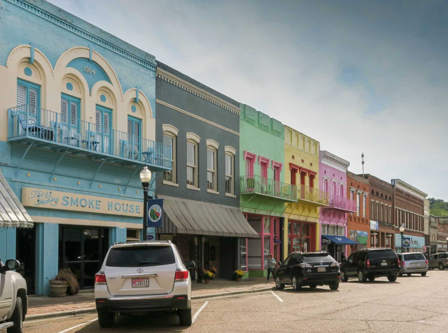 Yazoo City street lined with colorful buildings in turquoise, green, yellow and pink.