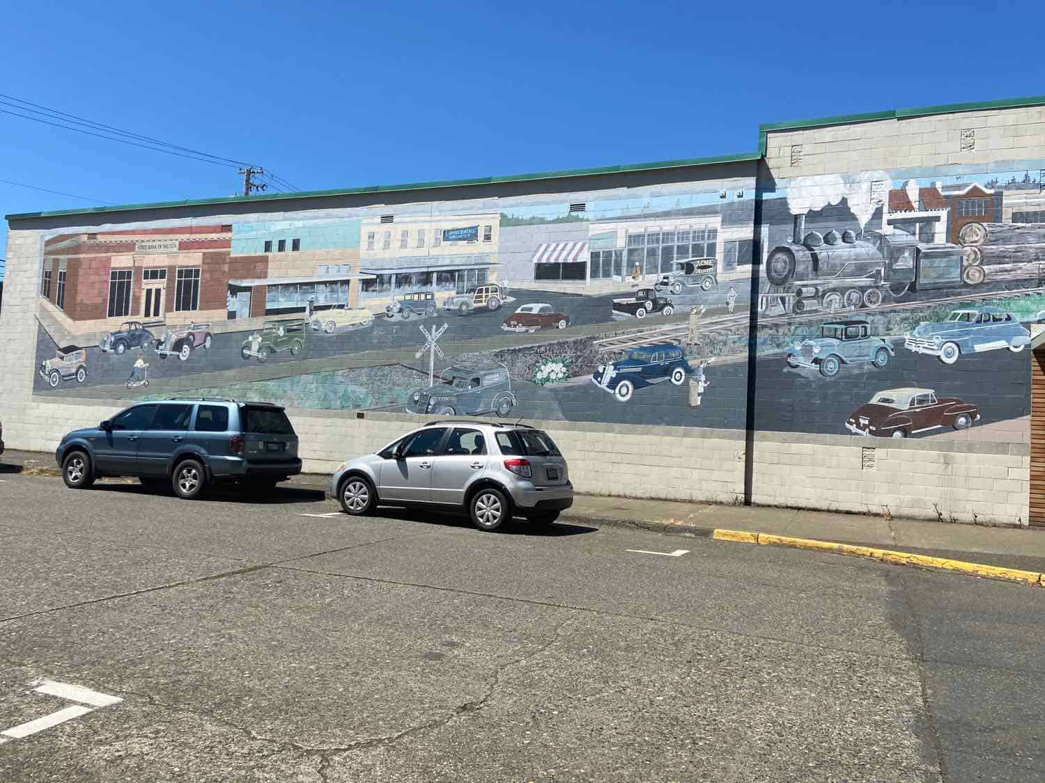 cars parked in front of a mural painted on a building in Shelton, Washington