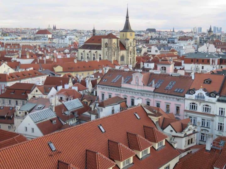 A Prague view that overlooks red tile roofs and church towers