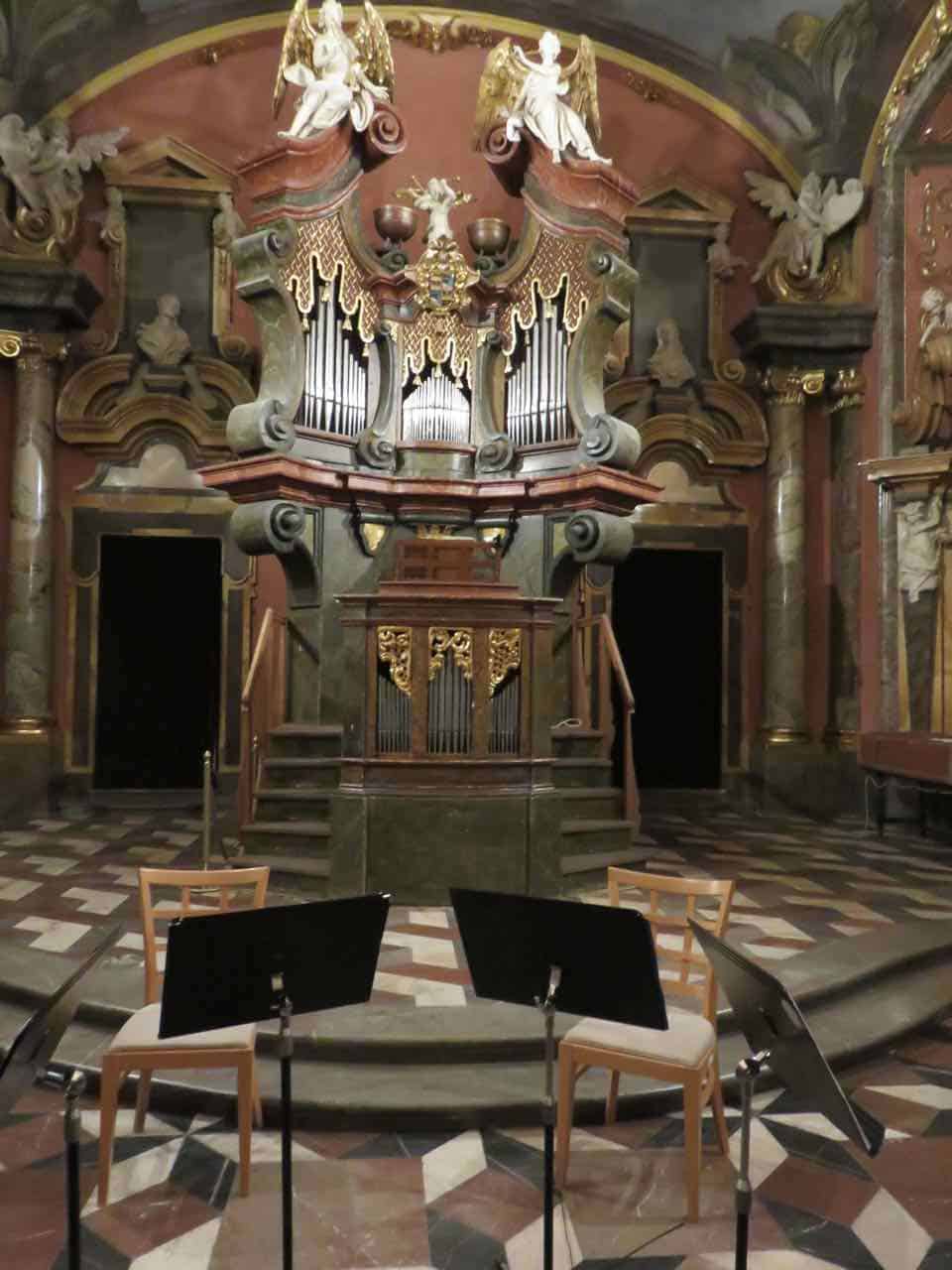 pipe organ in the center of an ornate chapel in prague