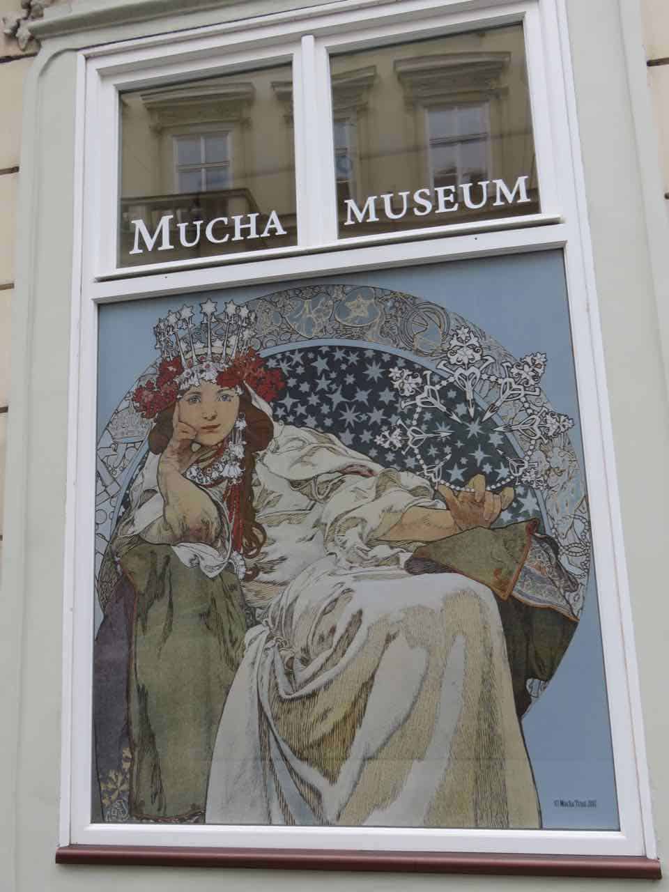 Art display in a window at the Mucha Museum in Prague