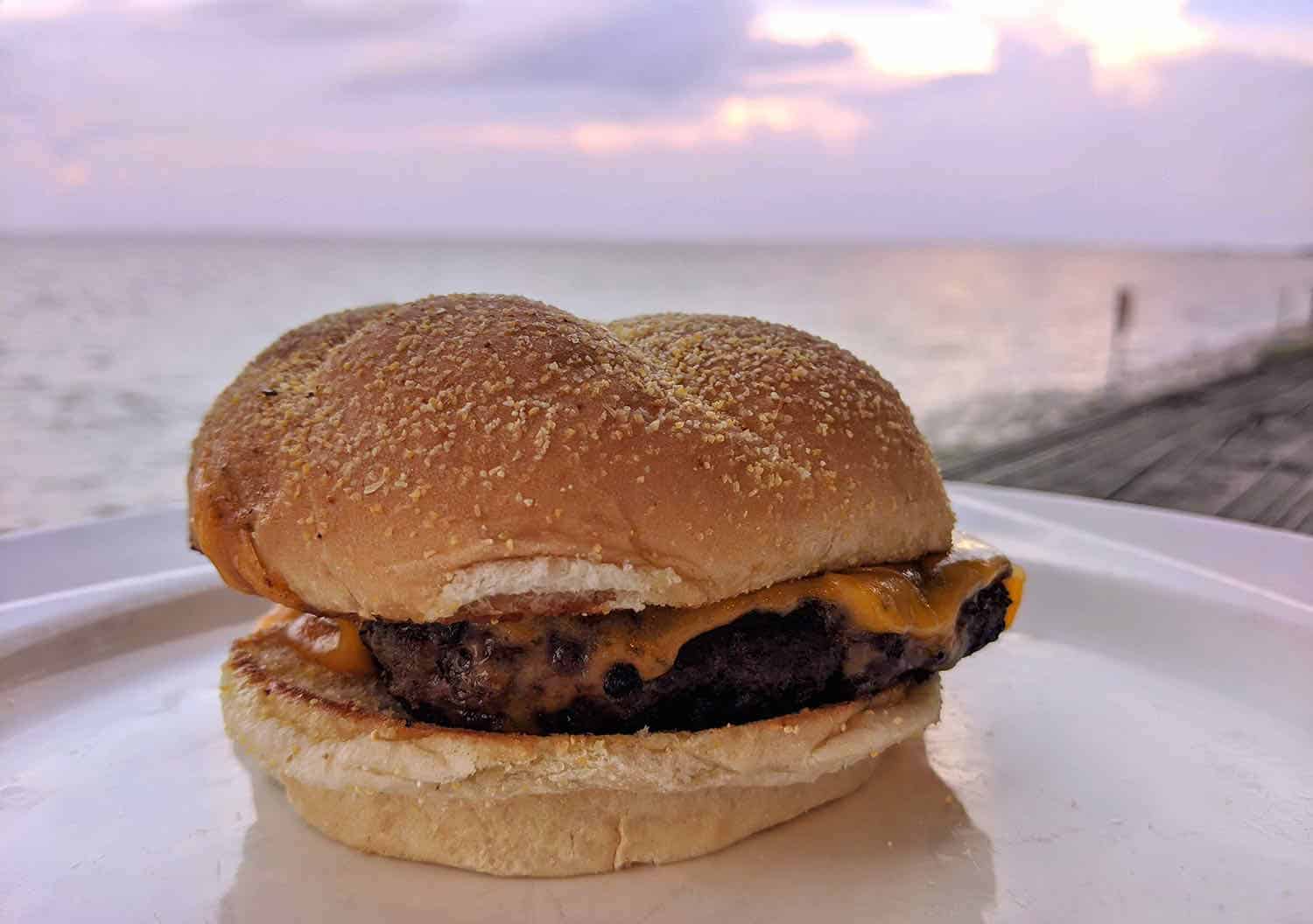 Hamburger on a plate with ocean in the background