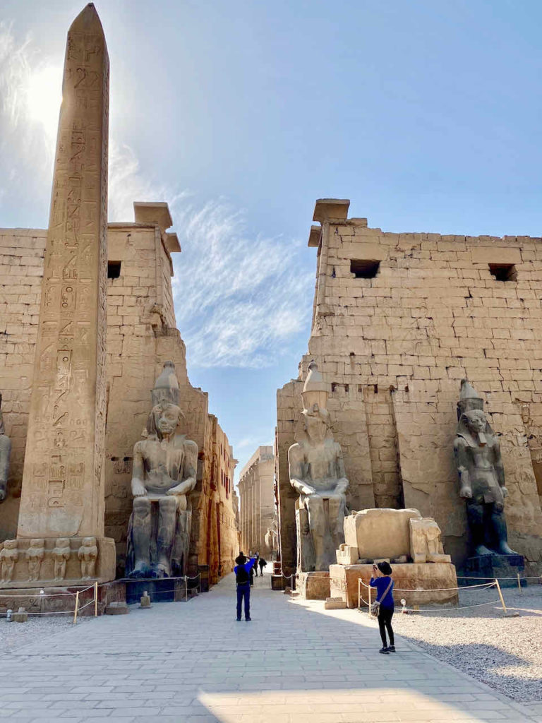 walkway flanked by statues and temples at Luxor