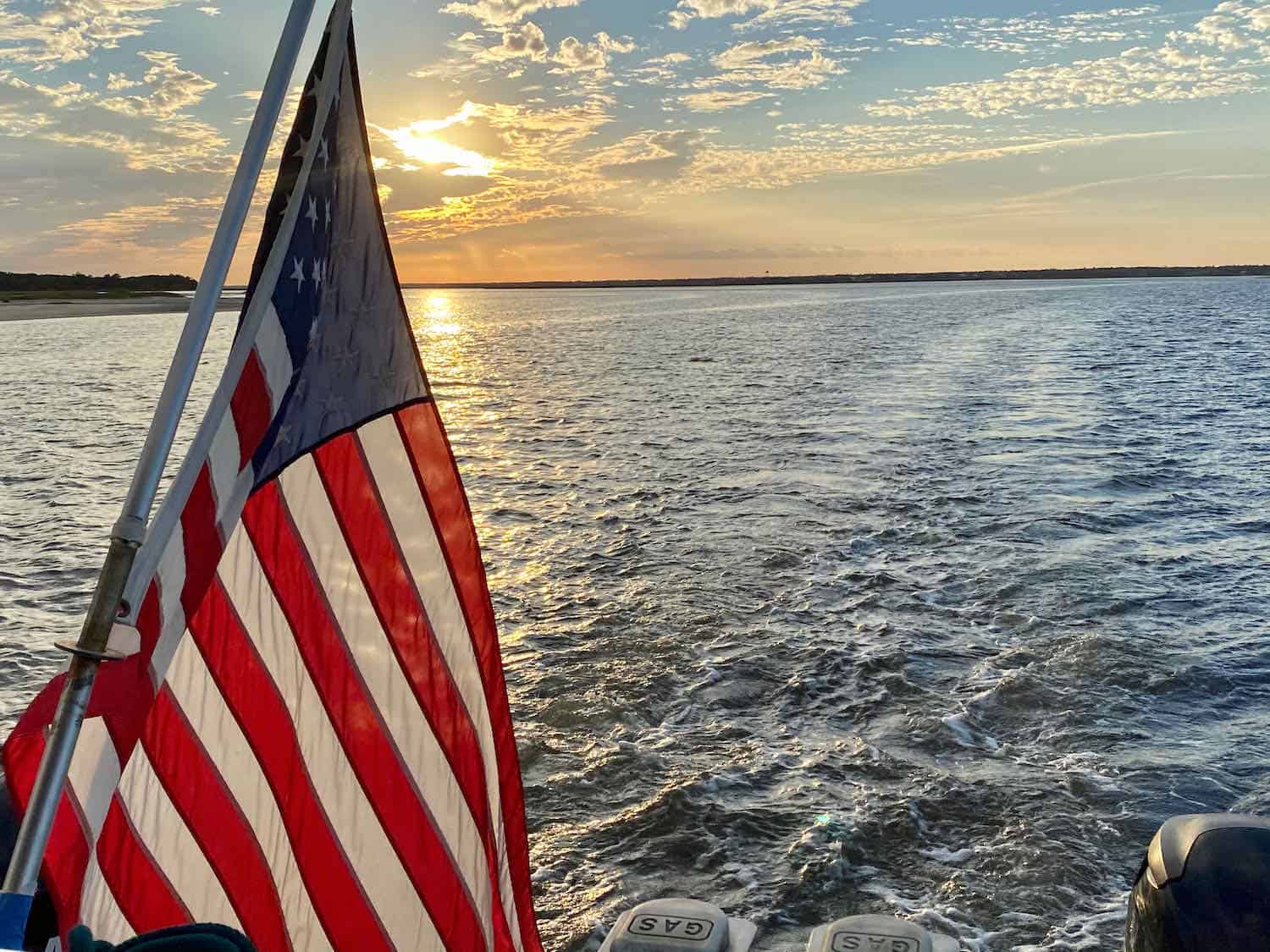 American flag on the back of a boat with water in the background