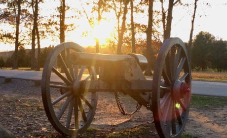 cannon with the sun setting behind it