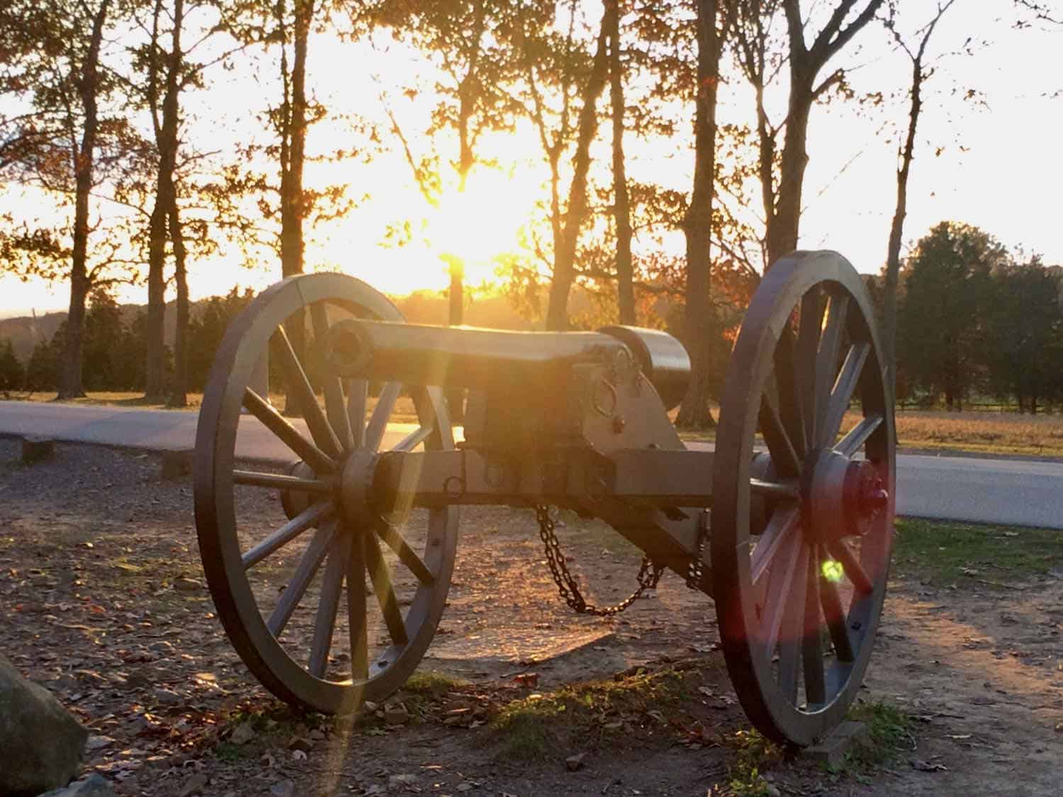 cannon with the sun setting behind it