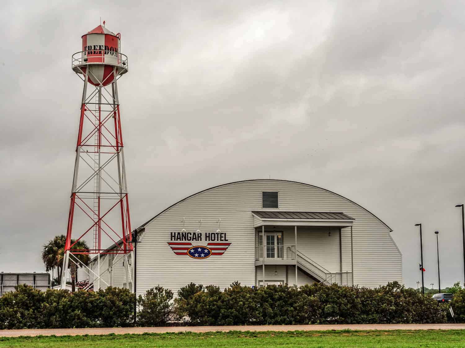 white hangar building with Hanger Hotel on the front in Fredericksburg, Texas.