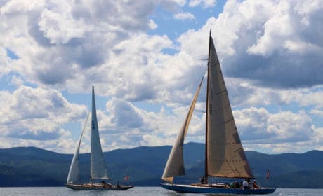 Two sailboats on Flathead Lake with lots of clouds in the sky.