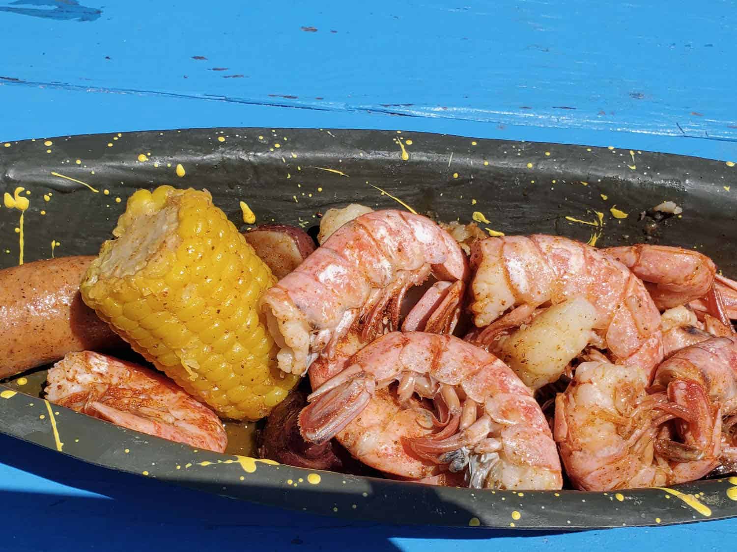 Plate of cooked shrimp and corn on the cob