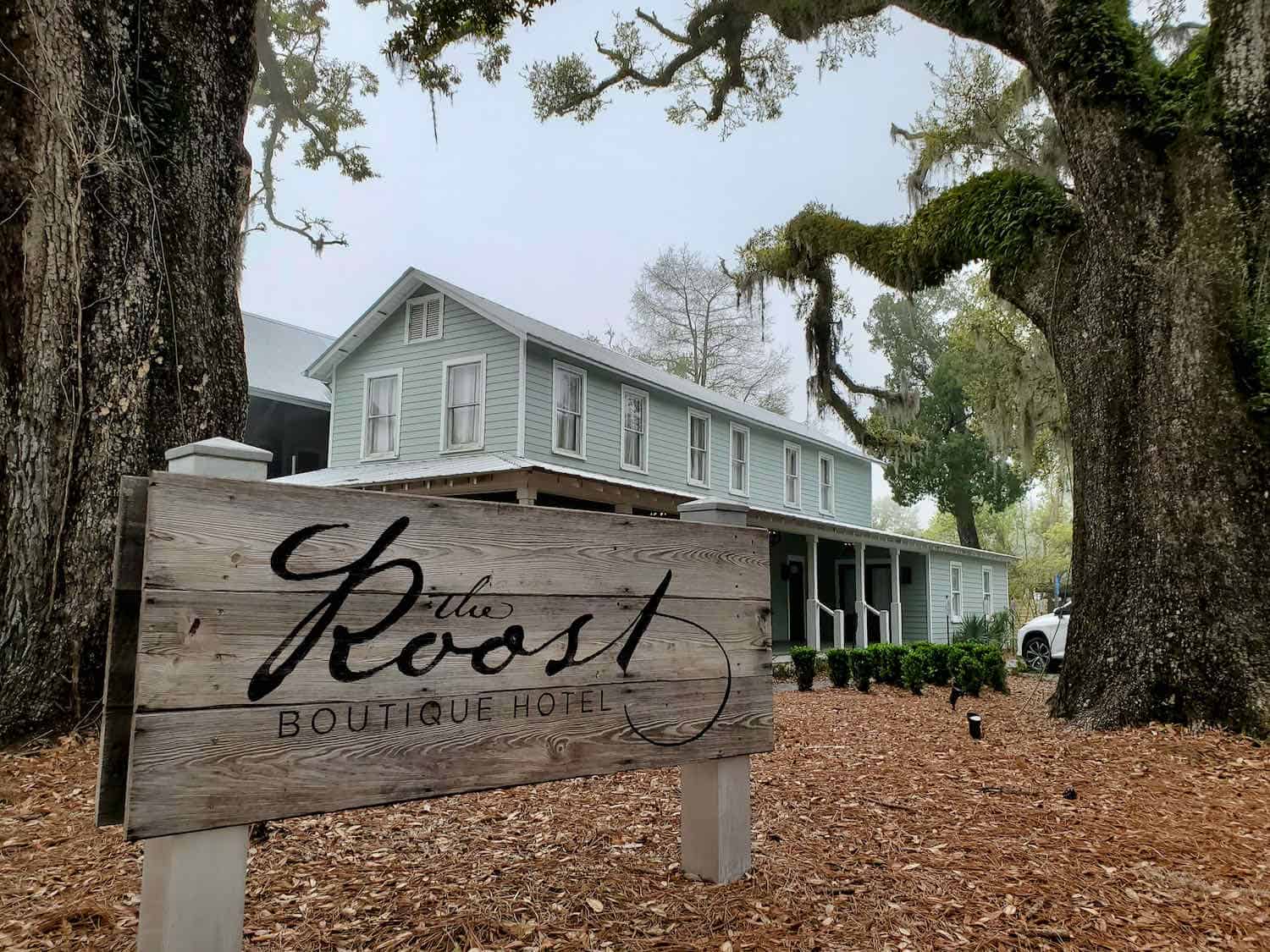 Pale green boutique hotel in between two live oaks in Ocean Springs, Mississippi