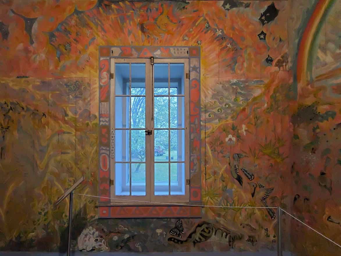 Colorful painting in orange and gold painted around a window