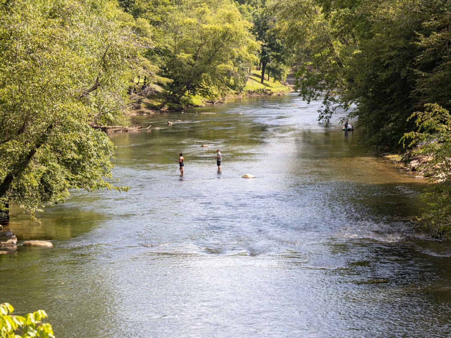 Two people standing in a river fly fishing near Blue Ridge, Georgia.