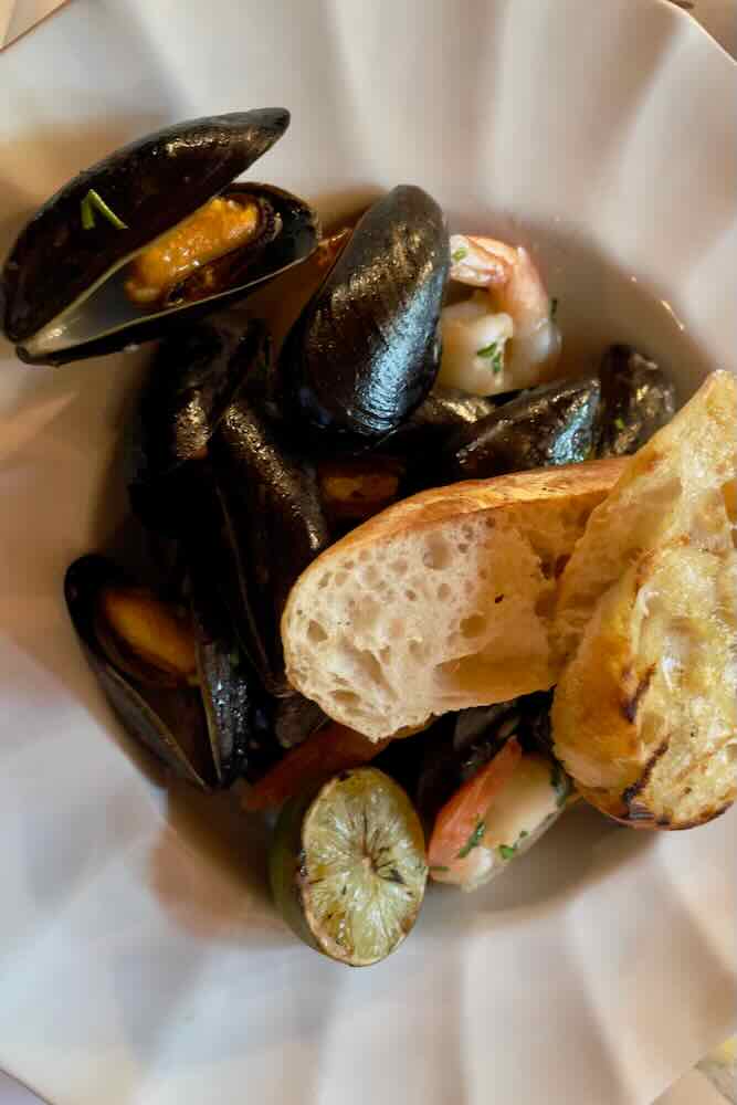 Steamed mussels in a bowl with garlic bread at Havana restaurant in Bar Harbor, Maine.